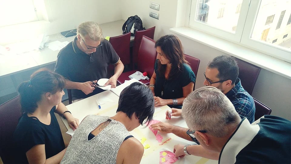 People sitting around a table cutting and arranging post-its